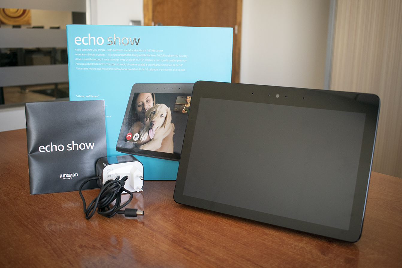 Caja del Amazon Echo Show junto al dispositivo, el cargador y la guía rápida