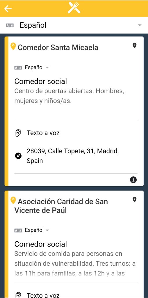 En la parte central, aparece un listado de entidades más cercanas que atienden la necesidad de `comida`. En la parte superior izquierda, hay un icono para retroceder al listado general de necesidades. Debajo de este, se puede seleccionar el idioma.